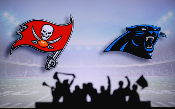Tampa Bay Buccaneers vs. Carolina Panthers. Fans support on NFL Game. Silhouette of supporters, big screen with two rivals in background.