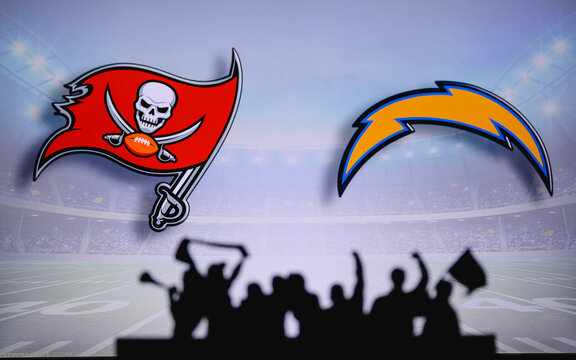 Tampa Bay Buccaneers vs. Los Angeles Chargers. Fans support on NFL Game. Silhouette of supporters, big screen with two rivals in background.