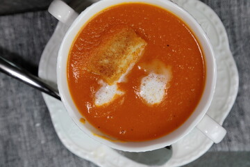 Homemade Tomato carrot soup in a bow made with frsh Tomatoes.