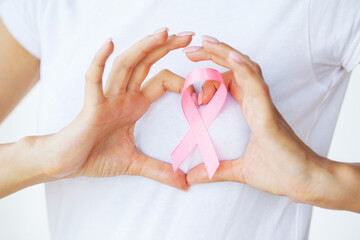 Close up of woman showing pink ribbon symbolizing breast cancer