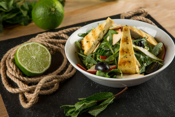 Fresh vegetable salad seasoned with oil on a wooden background