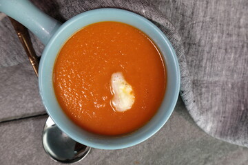 Homemade Tomato carrot soup in a bow made with frsh Tomatoes.