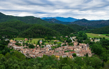 Fototapeta na wymiar A panoramic view of an old Catalan town Sant Llorenç de la Muga with buildings on the hills of the Spanish Pyrenees mountains in winter