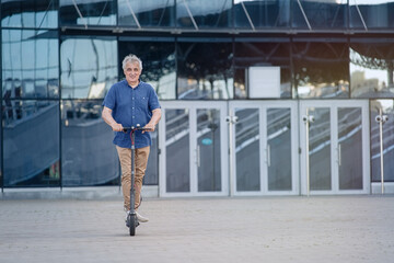 Senior man riding electric scooter in a cityscape  