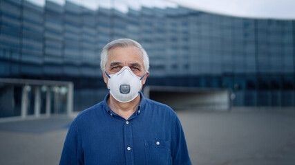 Portrait of a senior man wearing protective mask on street city    