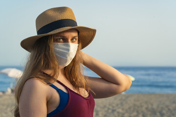 Young blonde woman wearing mask at the beach