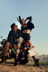 Tuinposter Sexy couple of bikers on the vintage custom motorcycle, girl in a rabbit mask © Georgii