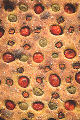Traditional Italian focaccia with olives, tomato, carrot and thyme - homemade flatbread focaccia. Sourdough focaccia. Top view.