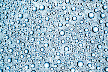 Water drops background. Wet glass surface texture. Bubble dew pattern. Transparent window blue...
