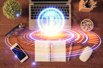 Blockchain theme hologram drawings over computer on the desktop background. Top view. Double...