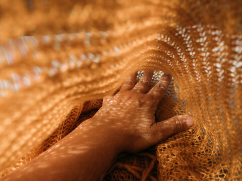 close up of a woman hands on orange fabric