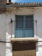 Fototapeta na wymiar Fachada de casa de pueblo con puerta azul en balcón, Comunidad Valenciana | Old mediterranean house with blue door 