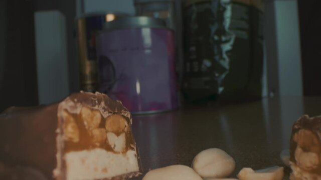 Macro close up view of the broken chocolate bar of chocolate with cashew nuts and coconut.
