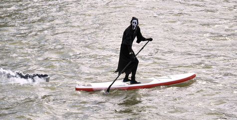 Death is floating on the SUP-board. halloween