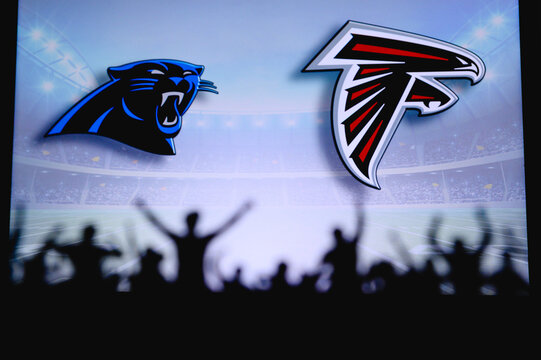 Carolina Panthers vs. Atlanta Falcons. Fans support on NFL Game. Silhouette of supporters, big screen with two rivals in background.