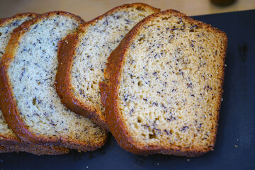 Sliced banana bread loaf on a black platter