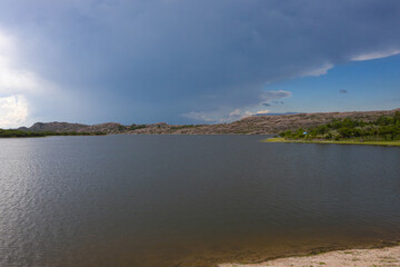 On the shores of a clean mountain lake with mountain peaks in the fond