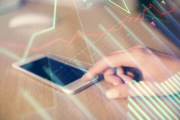 Double exposure of forex chart sketch hologram and woman holding and using a mobile device. Financial market concept.