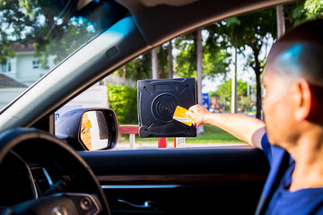 Selective focus to RFID reader with blur driver use key card to open the door for safety. Driver hold card to scan at RFID card reader station for open the car park door. Security system for parking.