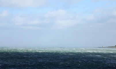 Carrickfergus is a large town in County Antrim, Northern Ireland. It sits on the north shore of Belfast Lough, 11 miles from Belfast. Featuring coastline with light house and stormy clouds.