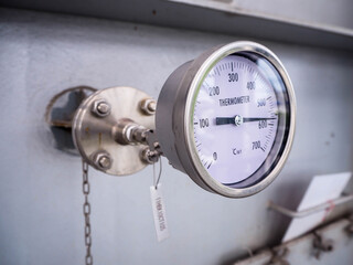 Temperature gauge for measuring instrument close up in industry zone at power plant.
