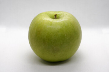 Close up view of a green apple. Taken inside a softbox with a white background