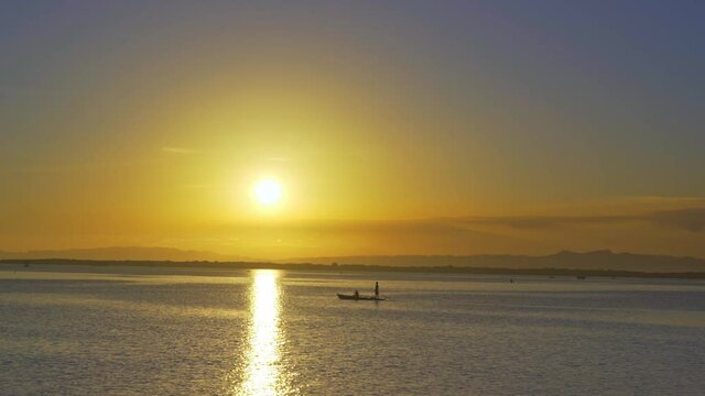 Seascape at sunset, father and son paddling a small fishing boat, Lapu-Lapu City, Cebu, Philippines