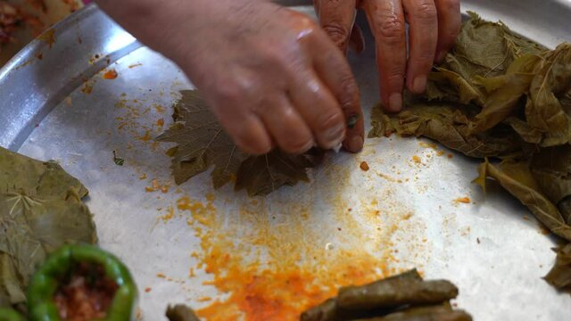 A woman is preparing stuffed grape leaves, leaf wrap, Turkish food culture and stuffed leaves