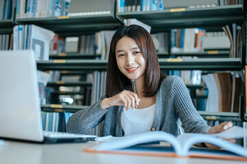 Fototapeta premium Student open a book and read for exam in the library. Education concept.