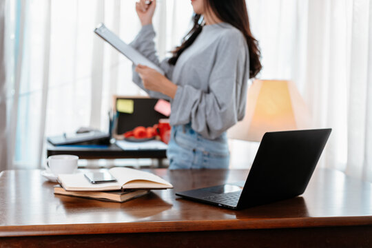 laptop on the table and student hold documant background. Student learning at home.