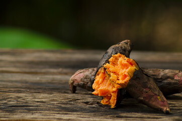 Sweet potato burned until cooked, flesh in yellow, laid on the old black wooden floor