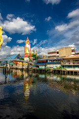 Obraz premium Background of a large Buddha statue in Bangkok (Wat Pak Nam Phasi Charoen), over 69 meters in height, stands majestically in the capital, a historical and cultural attraction that tourists come to see