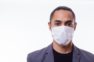 Close up of young Latino businessman with medical mask. Latin teacher with medical mask in white background.. Copy Space. Covid-19 concept.