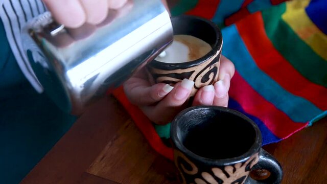 Woman&acute;s hands serving coffee with milk