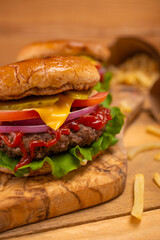 Fast and tasty food, hamburgers or burgers with french fries on a wooden table and on a wooden background