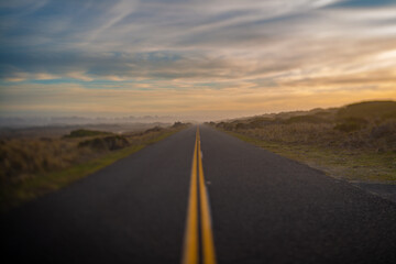 Selectively blurred road and horizon with sunset sky.