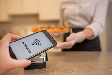 Payment by contactless payment for pizza in a restaurant or cafe, cashless payments, banking services. A new life according to the rules for coronavirus