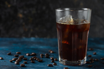 Cool cooling flight drink, iced coffee on a blue background, with coffee grains, summer mood