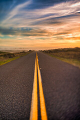 Fototapeta na wymiar Highway with yellow lines and sunset sky, selective focus. Dreamy pic