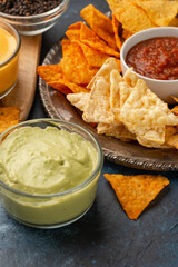 Different types of potato chips with salsa, and various types of dip, and seasonings, party and watching movies or football