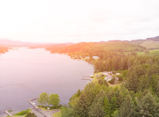 Shore of a bay or river or lake, against the background of the forest, aerial view at sunset