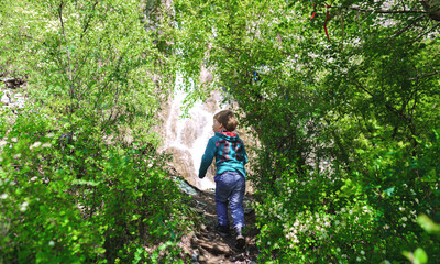 Naklejka na ściany i meble enthusiastic child goes to the waterfall