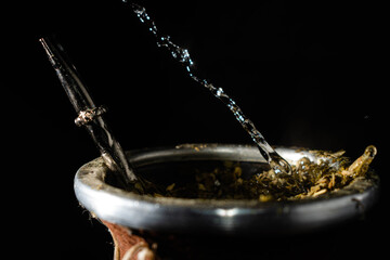 primer plano de mate argentino cebado con agua caliente y yerba a alta velocidad  © patoouupato