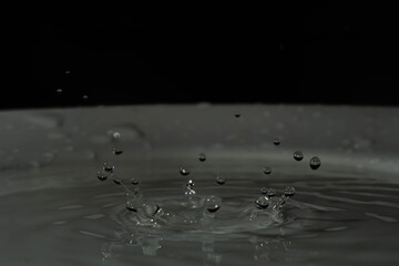 splash de gotas de agua sobre base blanca y fondo negro
