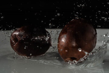 splash de aceituna negra sobre agua en alta velocidad 