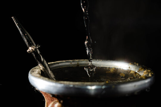 primer plano de mate argentino cebado con agua caliente y yerba a alta velocidad 