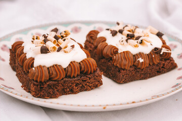 chocolate brownie cake with dulce de leche and cream on a plate