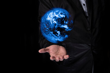 The businessman reaches out his hand up to hold touch screen earth background