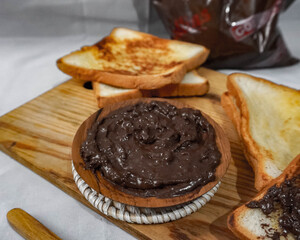 Sweet chocolate is served with delicious toast on a white background