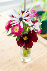 bouquet of wild flowers in a vase on bamboo table